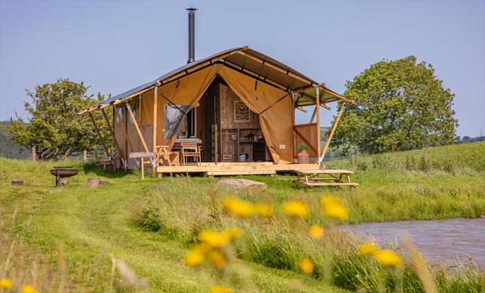 safari tent by a pond